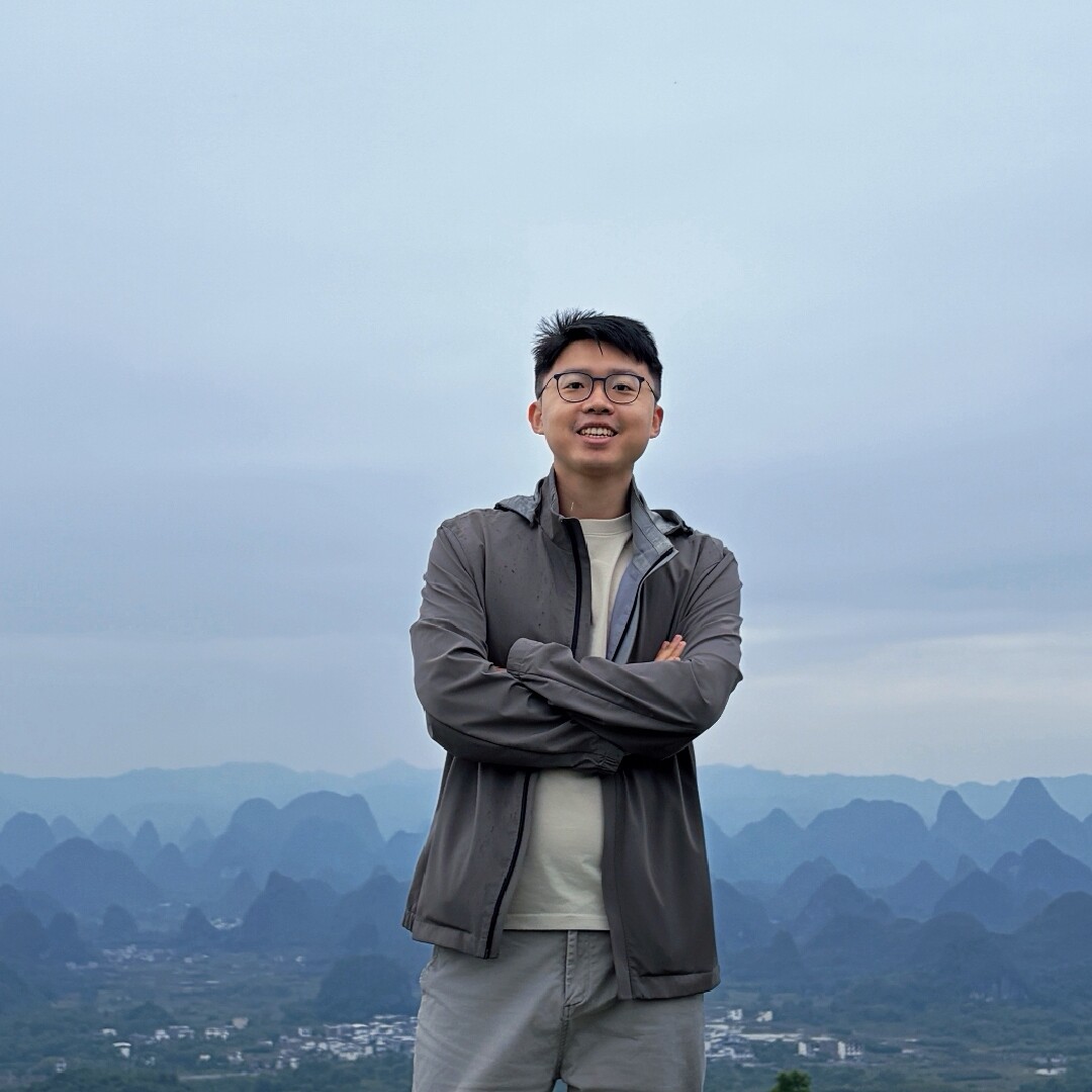 Junjie Chen outdoors with mountains in the background